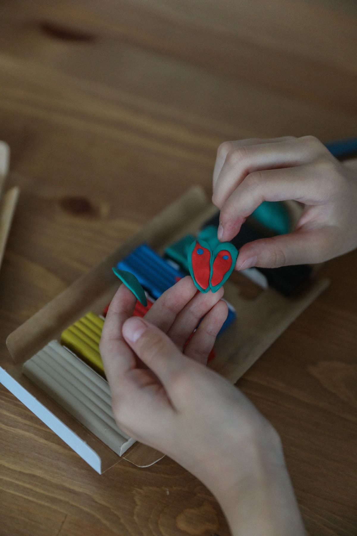 カラフルな粘土で工作をする子どもの手元